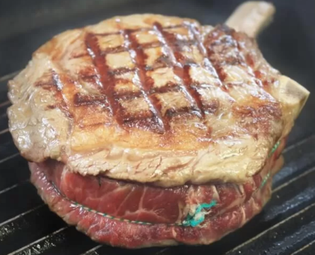 A steak cut frying in a griddle pan